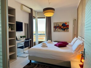A hotel room with a bed, a desk, a chair, a TV, a painting, and a view of the city. - 160 sqm apartment with a spectacular 180° view of Verona (Verona)