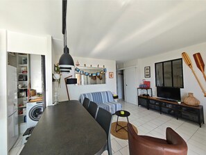 Ein Wohnzimmer mit Sofa, Fernseher und zwei Holzschlägern an der Wand.