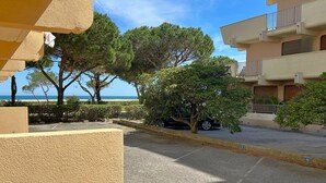 A residential area with a paved road, parked cars, and trees. - Beachfront studio, AC - 2 guests (Argelès-sur-Mer)