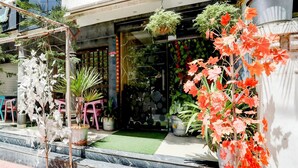 A storefront with potted plants and a small seating area outside. - Deluxe Easy Stay (Bhopal)