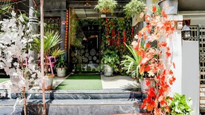 A storefront with a variety of potted plants and flowers displayed outside. - Deluxe Easy Stay (Bhopal)