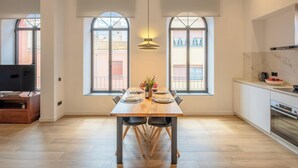 Una cocina moderna con comedor, ventanas amplias y televisor.