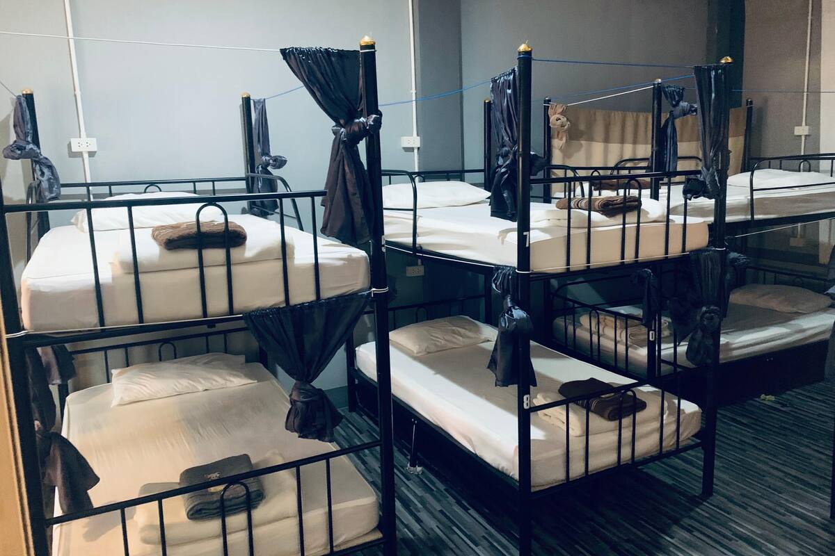 Bunk beds with curtains, a power outlet, and a carpeted floor.