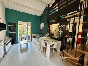 Una cocina moderna con comedor, un sofá y una escalera.
