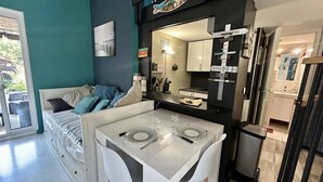 Ein gemütlicher Wohnbereich mit Küchenzeile, einer Essecke mit Tisch für zwei Personen und einem Bett mit Blick.