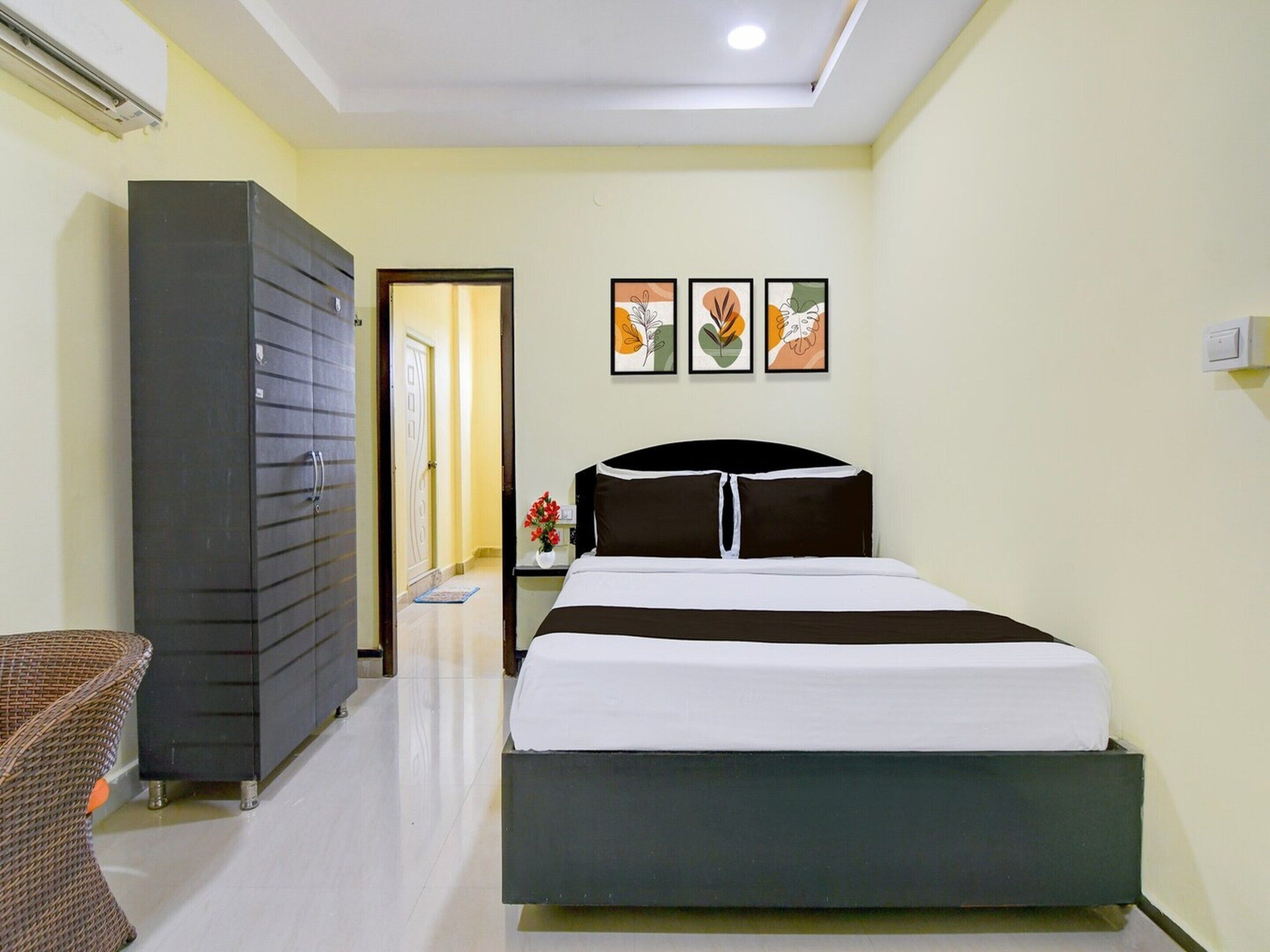 A hotel room with a bed, a wardrobe, a nightstand, and a chair.