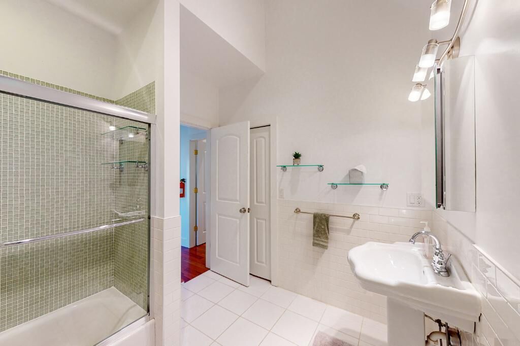 A bathroom with a shower, a sink, and a mirror.