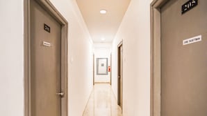 A hotel hallway with doors labeled '2011' and '205', a fire extinguisher, and a sign instructing to use the dustbin. - Deluxeorient Royale Nagpur (Nagpur)