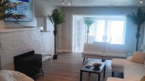 Una sala de estar con chimenea, un sofá, una silla y una mesa de centro.