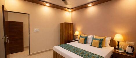 A hotel room with a bed, bedside lamps, a nightstand, a coffee maker, and a ceiling fan.