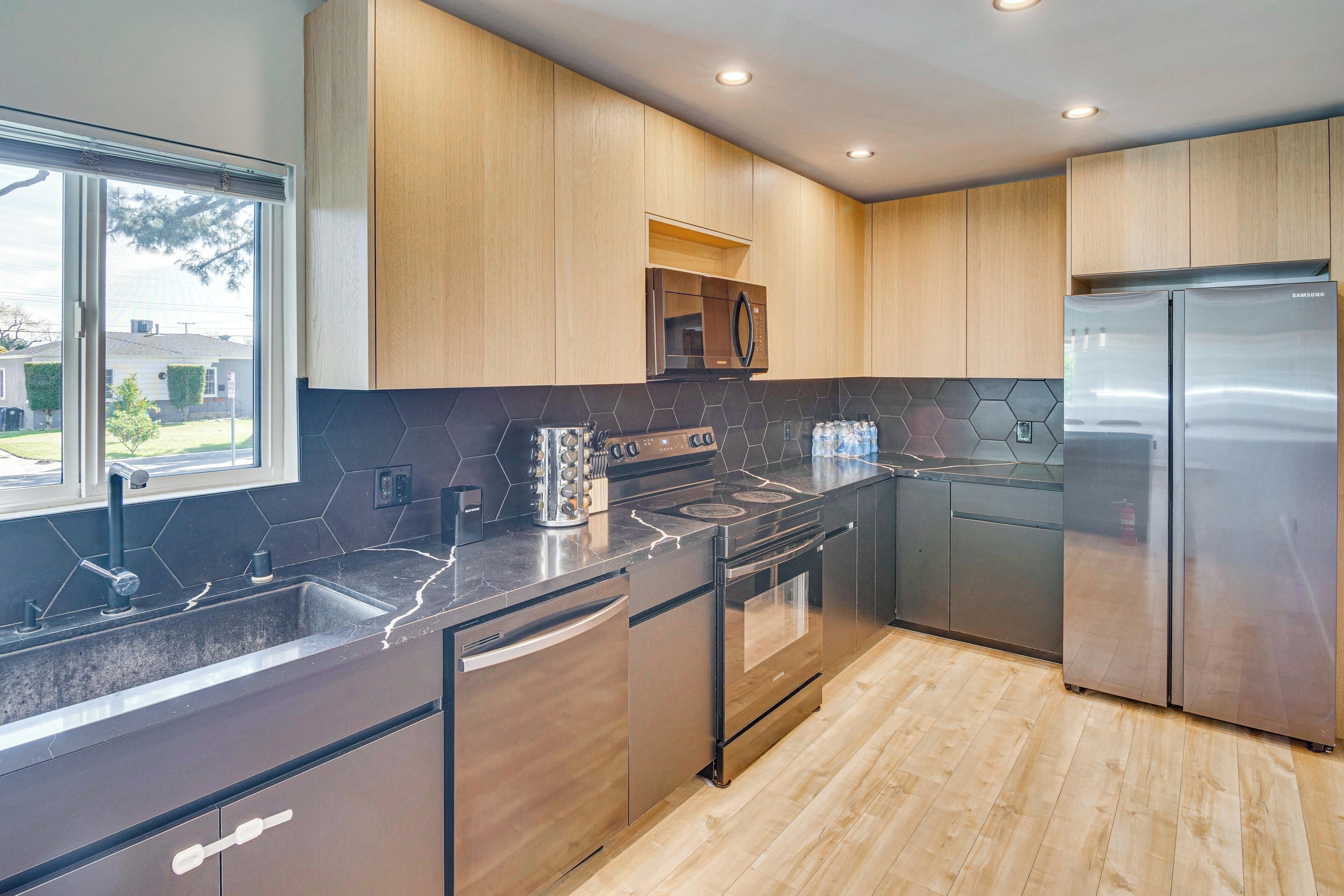 A modern kitchen with a stainless steel refrigerator, built-in oven, and microwave.