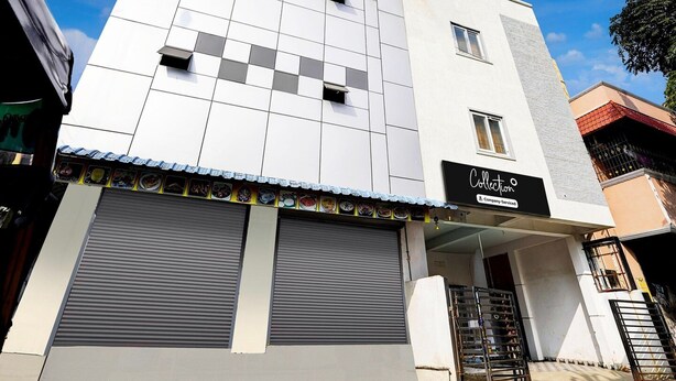 A modern building with a flat roof, a large garage door, and a sign that reads 'Collection Company Services.' - Deluxe Vinayak Residency Patravakam Inn (Chennai)