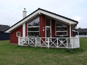 A red building with a white porch and a chimney. - 4 Star Holiday Home in Grossenbrode (Grossenbrode)