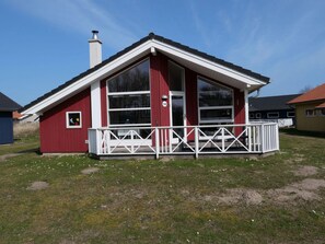 A red building with a white porch, large windows, and a chimney. - 4 Star Holiday Home in Grossenbrode (Grossenbrode)