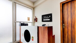 A reception area with a wooden desk, a sign reading 'Collection,' and a door with a brass handle. - Super Collection O Sadar Bazar Gurgaon (Gurugram)