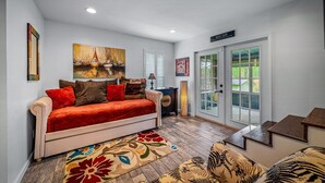 A living room with a sofa, a rug, and a painting on the wall. - Drop A Line – Riverfront Relaxation on Little Riverer (Mentone)