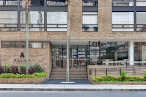 A modern building with a brick facade, large windows, and a sign reading 'AGOA HOUSES'. - w Loft Haven in the Heart of Bogot (Bogotá)