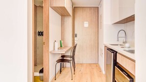 A compact kitchen with a built-in oven, a sink, and a wooden cabinet. - w Designer Loft in the Heart of Bogot (Bogotá)