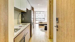 A modern kitchen with a built-in oven, a sink, and a window with a view of buildings. - w Signature Loft in the Heart of Bogot (Bogotá)