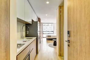 A modern kitchen with a built-in oven, a sink, and a window with a view of buildings. - w Signature Loft in the Heart of Bogot (Bogotá)