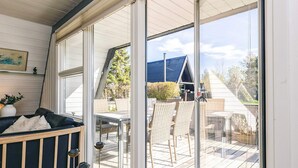 A room with a glass door leading to an outdoor deck with a table and chairs. - 4 Star Holiday Home in Farso (Farso)