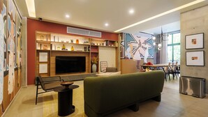 A modern living room with a sofa, a TV, a fireplace, and a dining area. - w Nest-style 1BR in Lively Tabacalera (Mexico City)