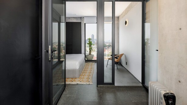 A modern apartment with a balcony, a bed, a potted plant, and a radiator. - w Nest-style 1BR in Lively Tabacalera (Mexico City)