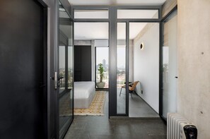 Ein modernes Apartment mit Balkon, einem Bett, einer Topfpflanze und einer Heizung.