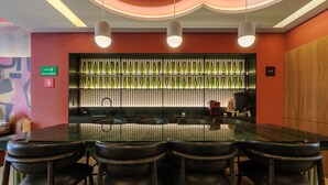 A conference room with a long table, four chairs, a bar area with bottles, and a sign indicating a smoking area. - w Nest-style 1BR in Lively Tabacalera (Mexico City)