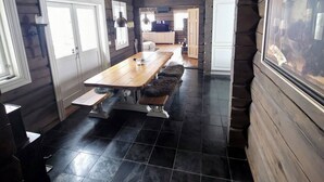 L’intérieur d’une cabane en rondins comprend un coin repas, une cuisine et un tableau encadré accroché au mur.