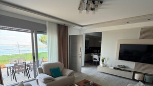 A modern living room with a sofa set, a coffee table, and a TV. - Cozy Family Villa close to the beach! (Vlora)