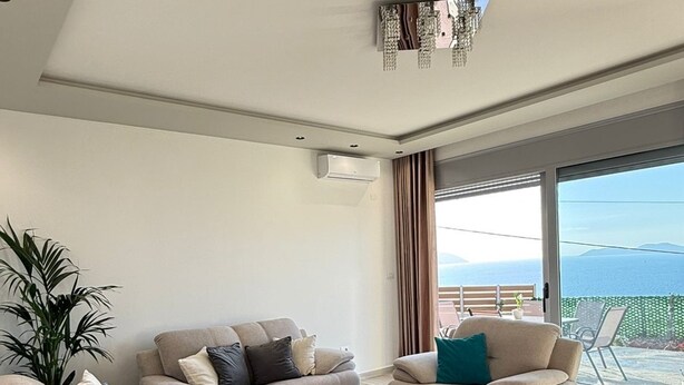 A modern living room with two sofas, a coffee table, and a large window with a view of the sea. - Cozy Family Villa close to the beach! (Vlora)