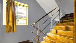 A staircase with a metal handrail and wooden steps. - Deluxe GL Classic (Alto de Porvorim)