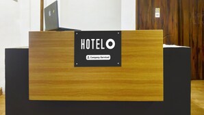 A hotel reception desk with a sign indicating it is company-serviced. - Deluxe GL Classic (Alto de Porvorim)