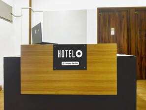A hotel reception desk with a sign indicating it is company-serviced. - Deluxe GL Classic (Alto de Porvorim)
