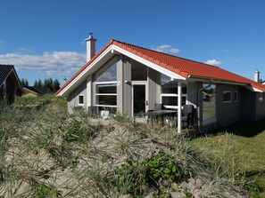 A coastal house with a red roof, large windows, and a visible chimney. - 4 Star Holiday Home in Grossenbrode (Grossenbrode)