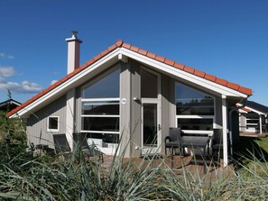 A modern house with a red roof, large windows, and a patio area. - 4 Star Holiday Home in Grossenbrode (Grossenbrode)