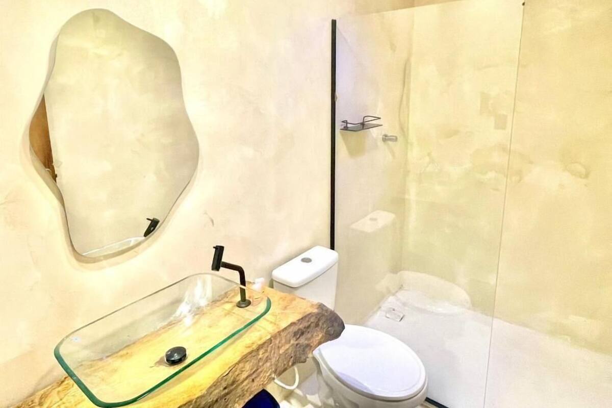 Et badeværelse med vask, toilet og bruseområde.