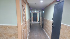 A hallway with wooden paneling, a black door, and a sign indicating room number 501.