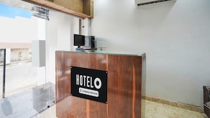 Ein Hotelrezeptionstresen mit einem Schild, auf dem 'HOTELO Company-Serviced' steht.