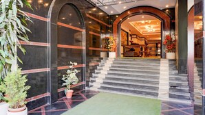 A hotel lobby with a marble staircase, potted plants, and a reception area. - Premiumhotel Seven Olive (Bengaluru)