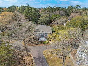 A house with a porch, surrounded by trees and a driveway. - The Escape 3 Bedroom Villa (Georgetown)