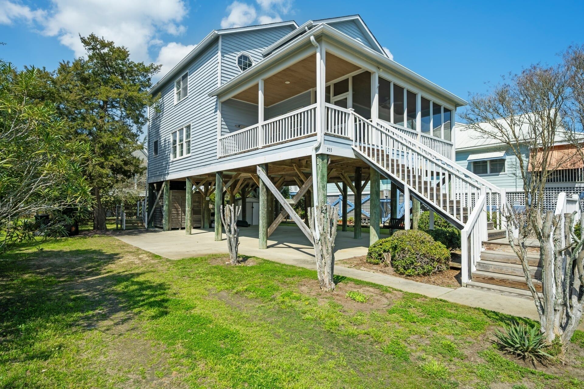 A two-story house with a porch and a staircase leading to the upper level.