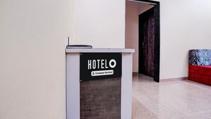 A reception desk labeled 'HOTELO' with a sign indicating it is company-serviced. - Hotel O Main Market Mahabaleshwar (Mahabaleshwar)