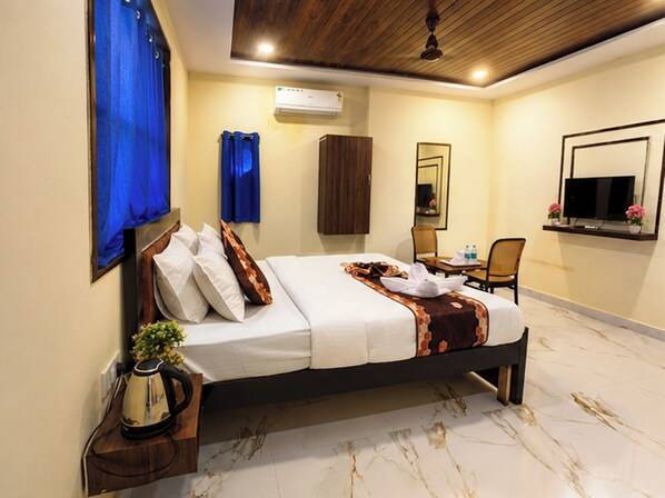 A hotel room with a bed, a television, a mirror, and a coffee maker. - Hotel Sky Palace (Hyderabad)
