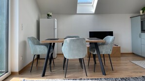Una cocina moderna con horno empotrado, un refrigerador blanco y un tragaluz sobre la zona de comedor.