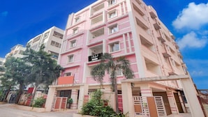 A multi-story residential building with balconies, a sign indicating a collection point, and a clear blue sky. - Super Collection O Kphb (Hyderabad)