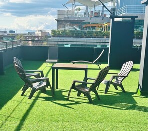 A rooftop terrace with artificial grass, a table, and four chairs. - Modern Suite Near Parque 93 | Premium Design & Prime Location (Bogotá)