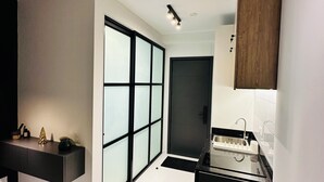 Une cuisine moderne avec un plan de travail noir, un évier et un meuble de rangement.