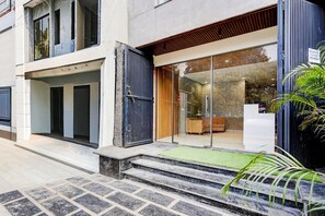 A modern building with a reception area, a staircase leading to the entrance, and a green mat at the base. - Classic With Balcony Sector 51 Gurgaon (Gurugram)